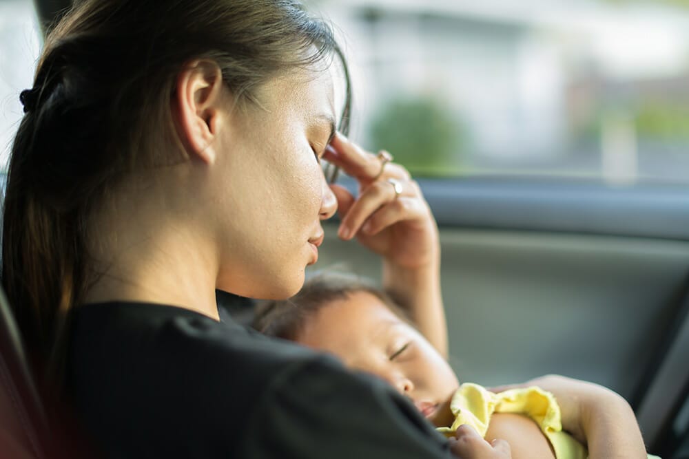 Tired stressed mother holding her baby.